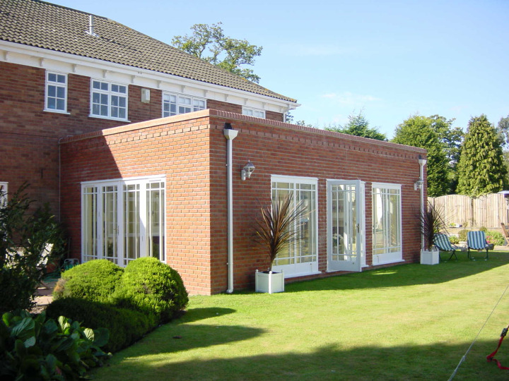 Brick orangery with two roof lanterns, French doors, parapet wall