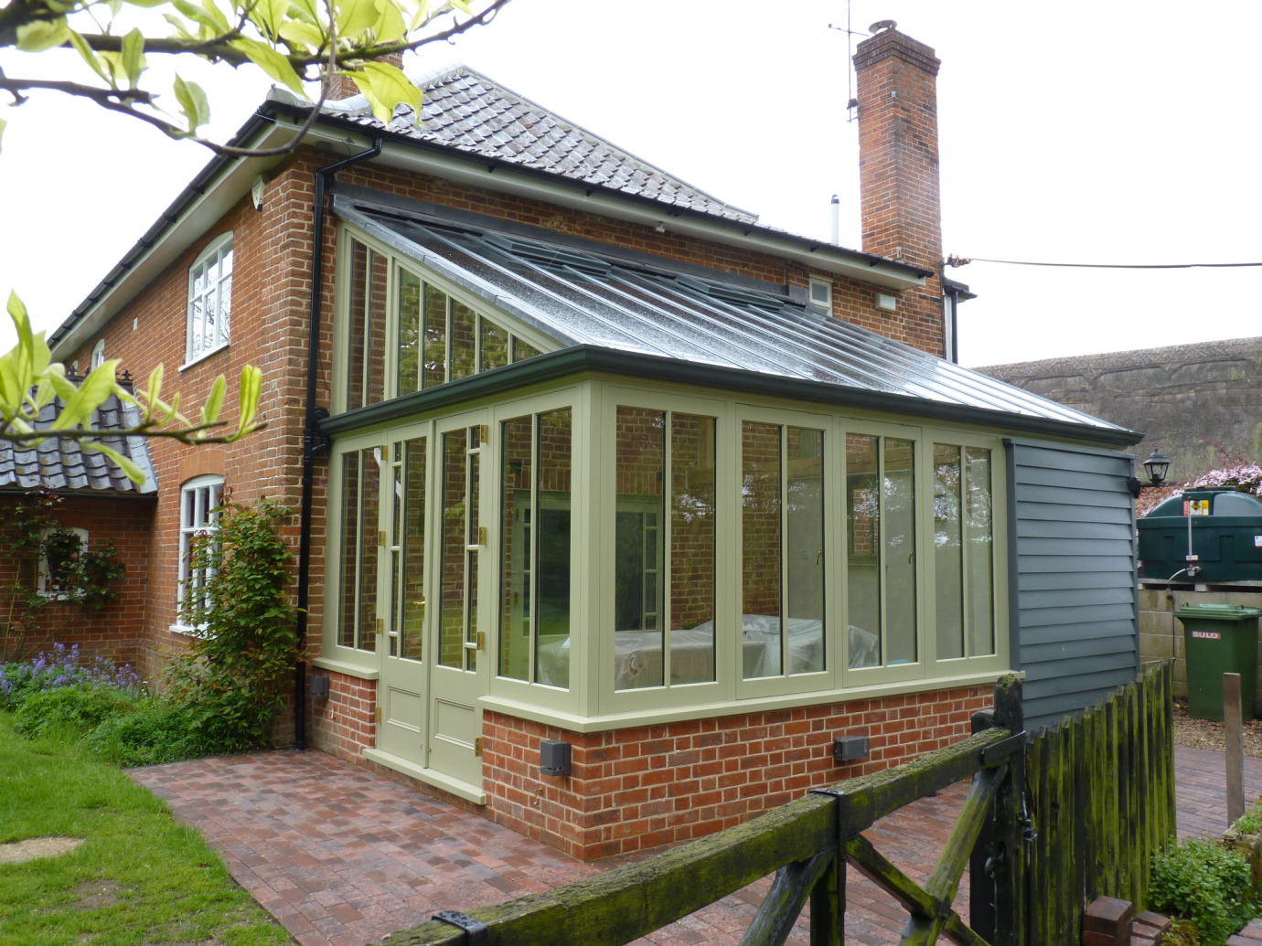Traditional style lean-to conservatory with timber-clad section